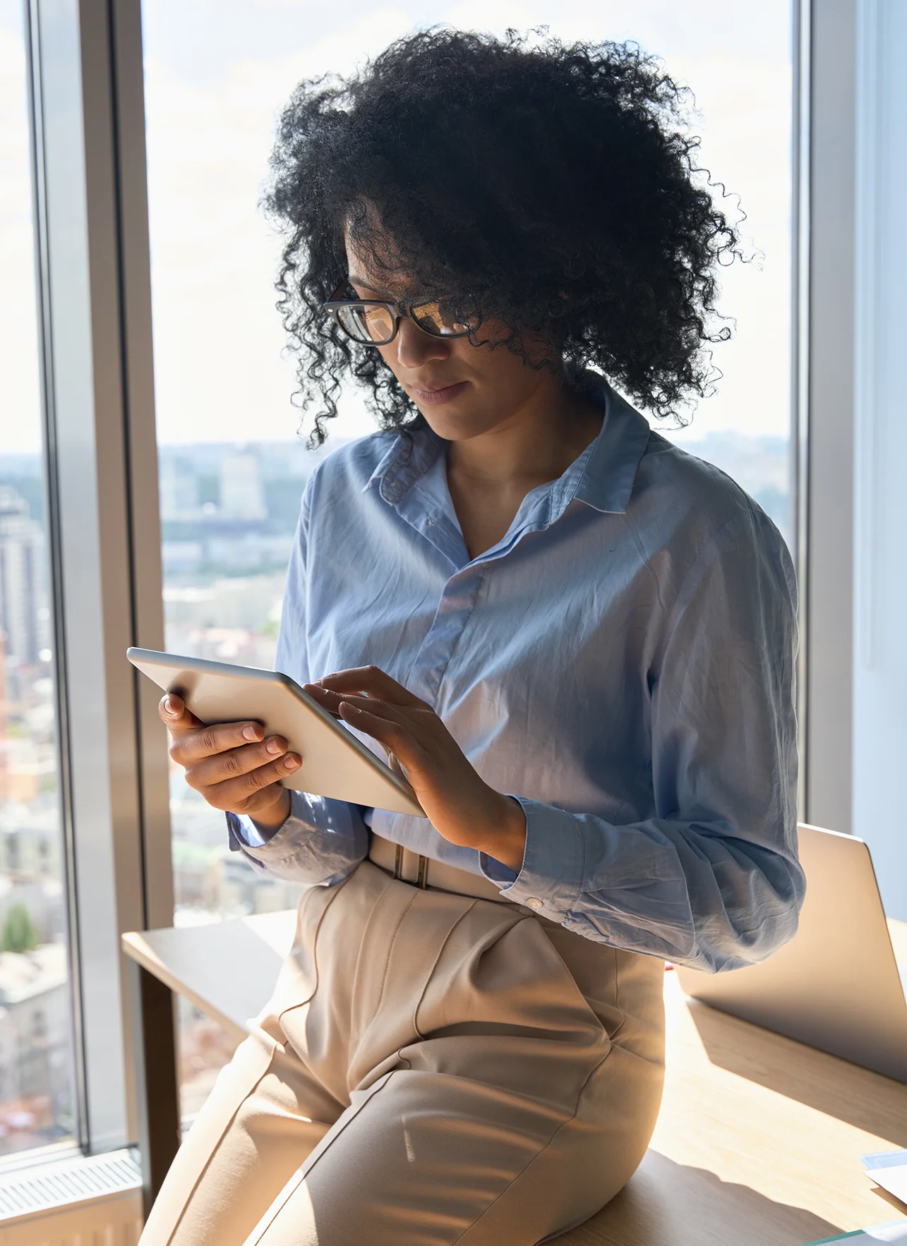 executive manager sitting on desk holding using tablet device executive manager sitting on desk holding using tablet device
