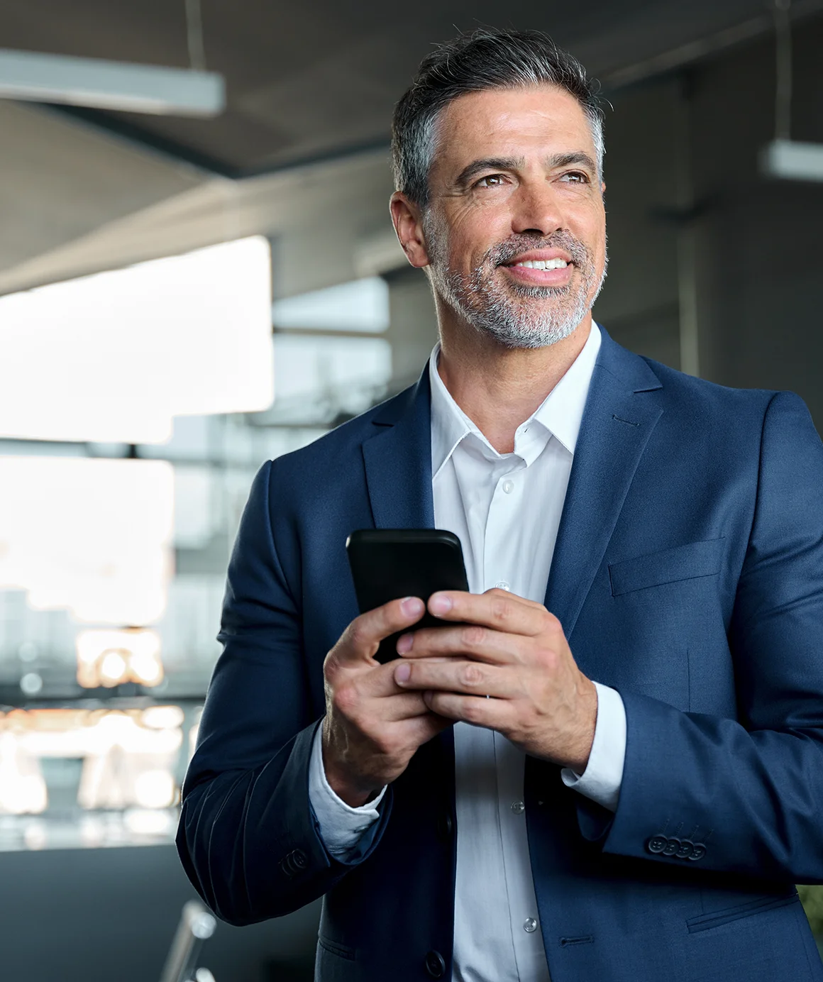 smiling happy confident mid aged male company ceo executive wearing suit holding cellphone
