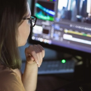 woman video montager mounts video at desktop