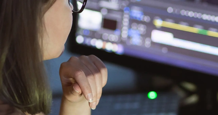 woman video montager mounts video at desktop