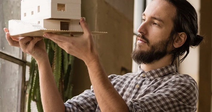 young architect is looking on the new model in the old industrial space
